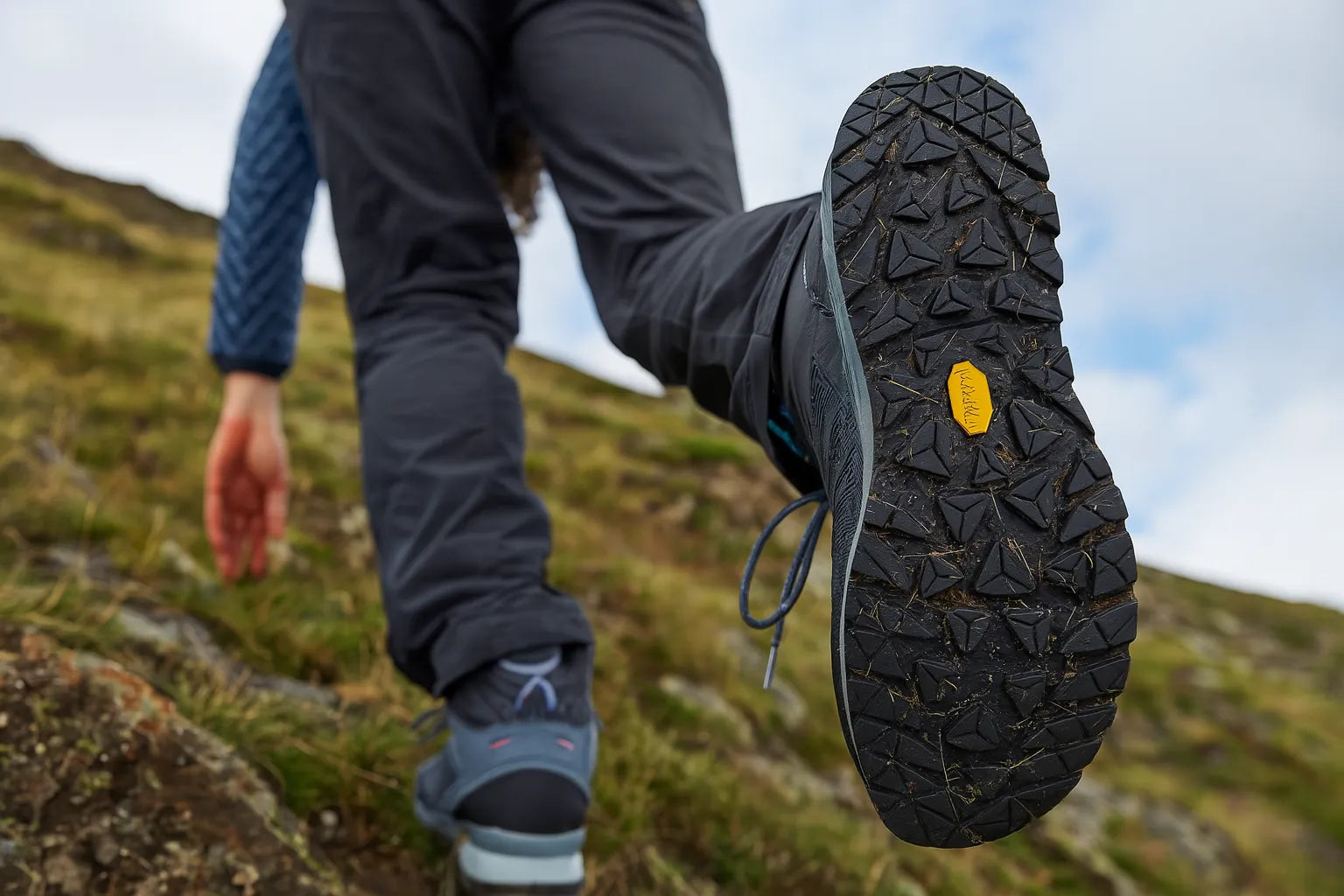 Chaussure de randonnée avec semelle vibram vue en contre-plongée sur pente raide.