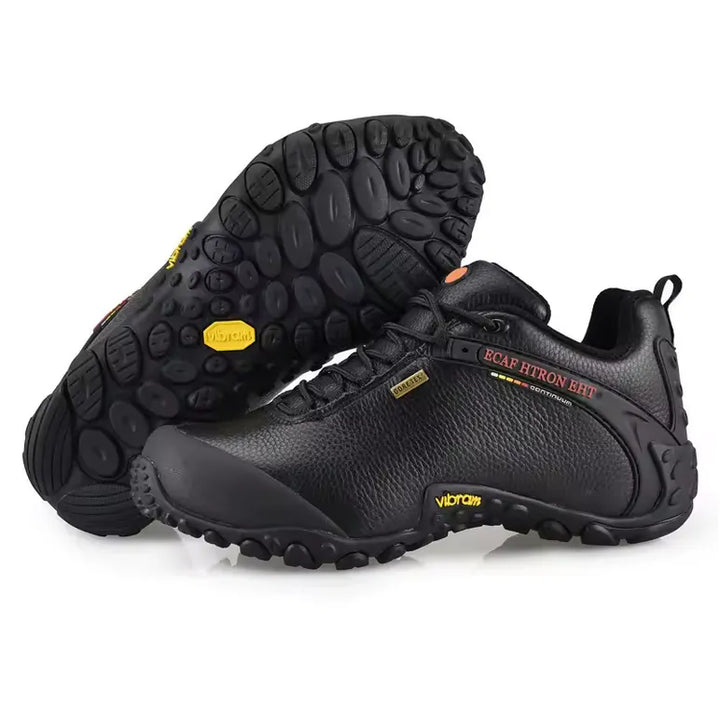 Chaussure de randonnée en cuir noir pour homme avec semelle Vibram à crampons et membrane Gore‑Tex imperméable, montrant la semelle antidérapante parfaite pour la marche et le bivouac.