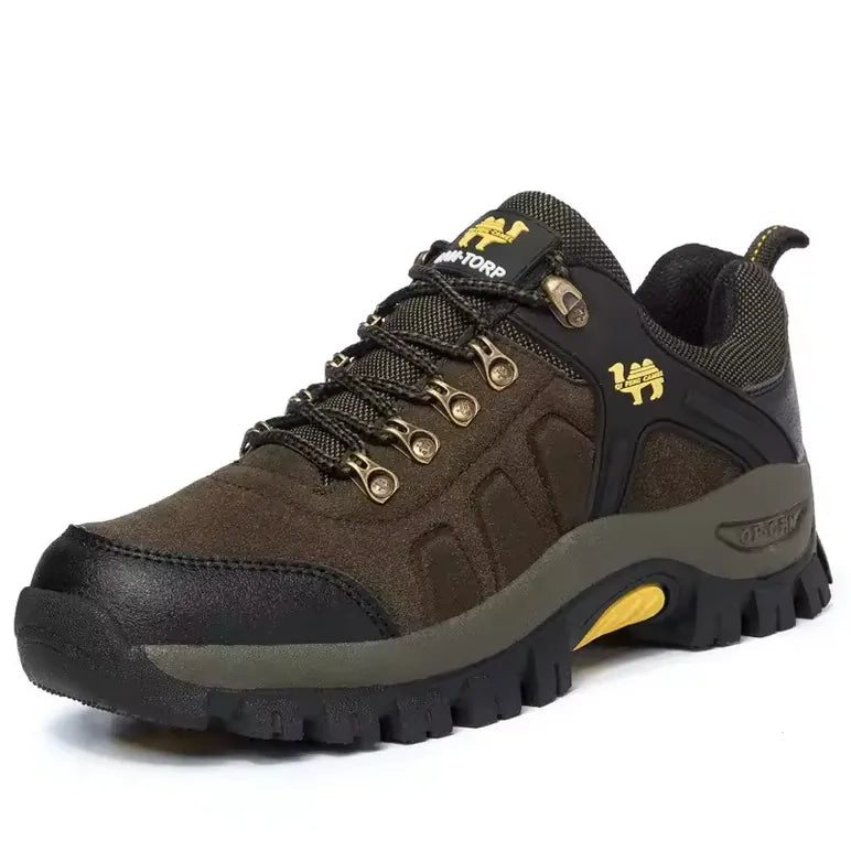 Chaussure de randonnée marron foncé pour homme avec accents jaunes et œillets métalliques, semelle crantée robuste pour trekking et marche en montagne.