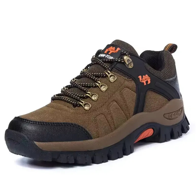 Chaussure de randonnée pour homme en daim marron avec renforts noirs et semelle crantée, détails orange, idéale pour trekking, trail et marches en plein air.
