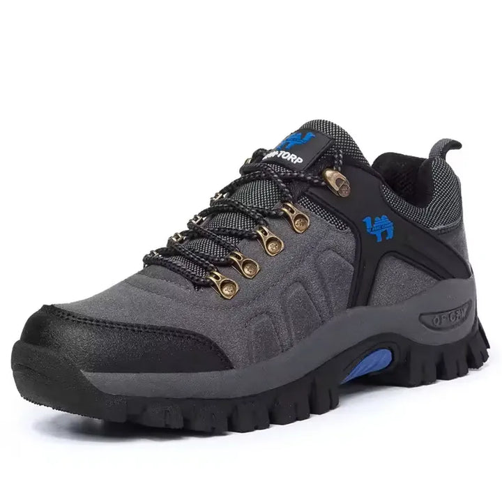 Chaussure de randonnée grise pour homme avec accents bleus et semelle à crampons, conception confortable pour activités outdoor comme la randonnée et le camping.