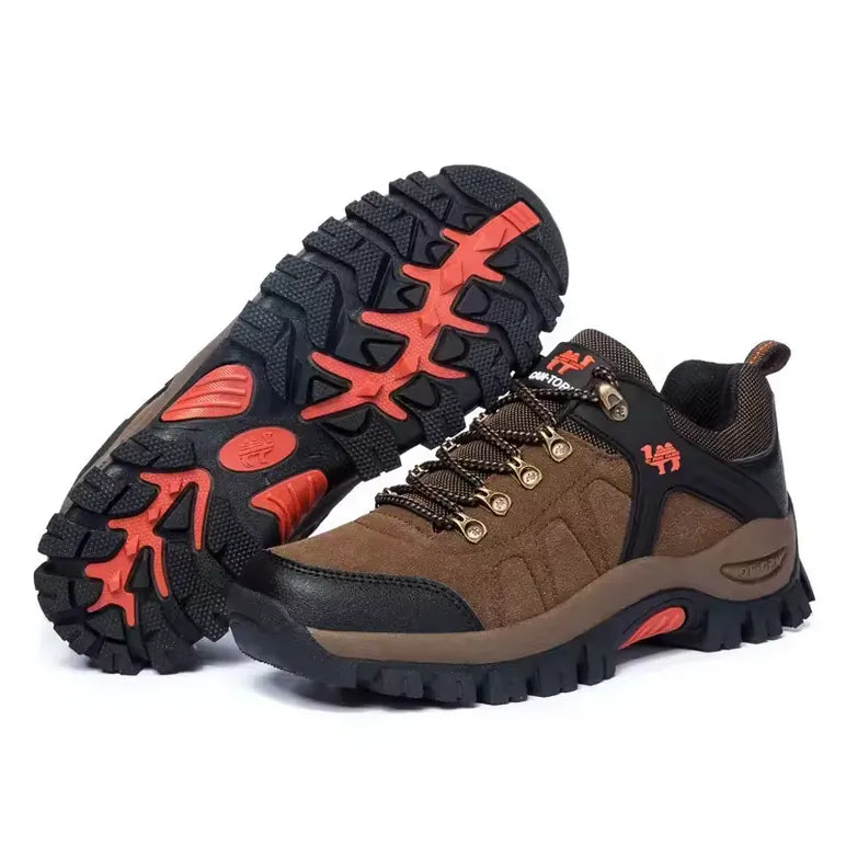 Paire de chaussures de randonnée marron avec semelle orange épaisse antidérapante, montrant la semelle à crampons et le dessus en daim durable.