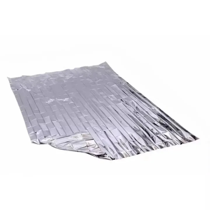 Couverture de survie thermique dépliée couleur argentée.