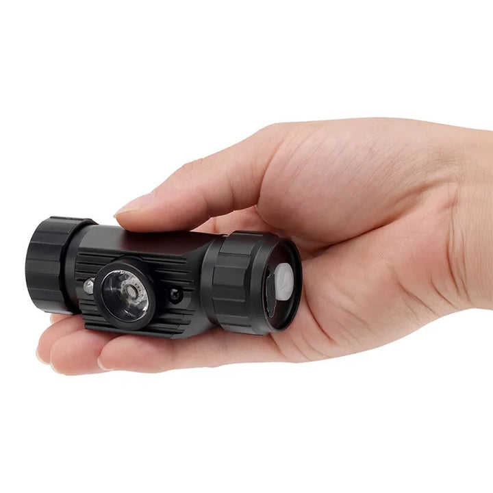 Grosse lampe frontale LED noire tenue en main vue en gros plan.