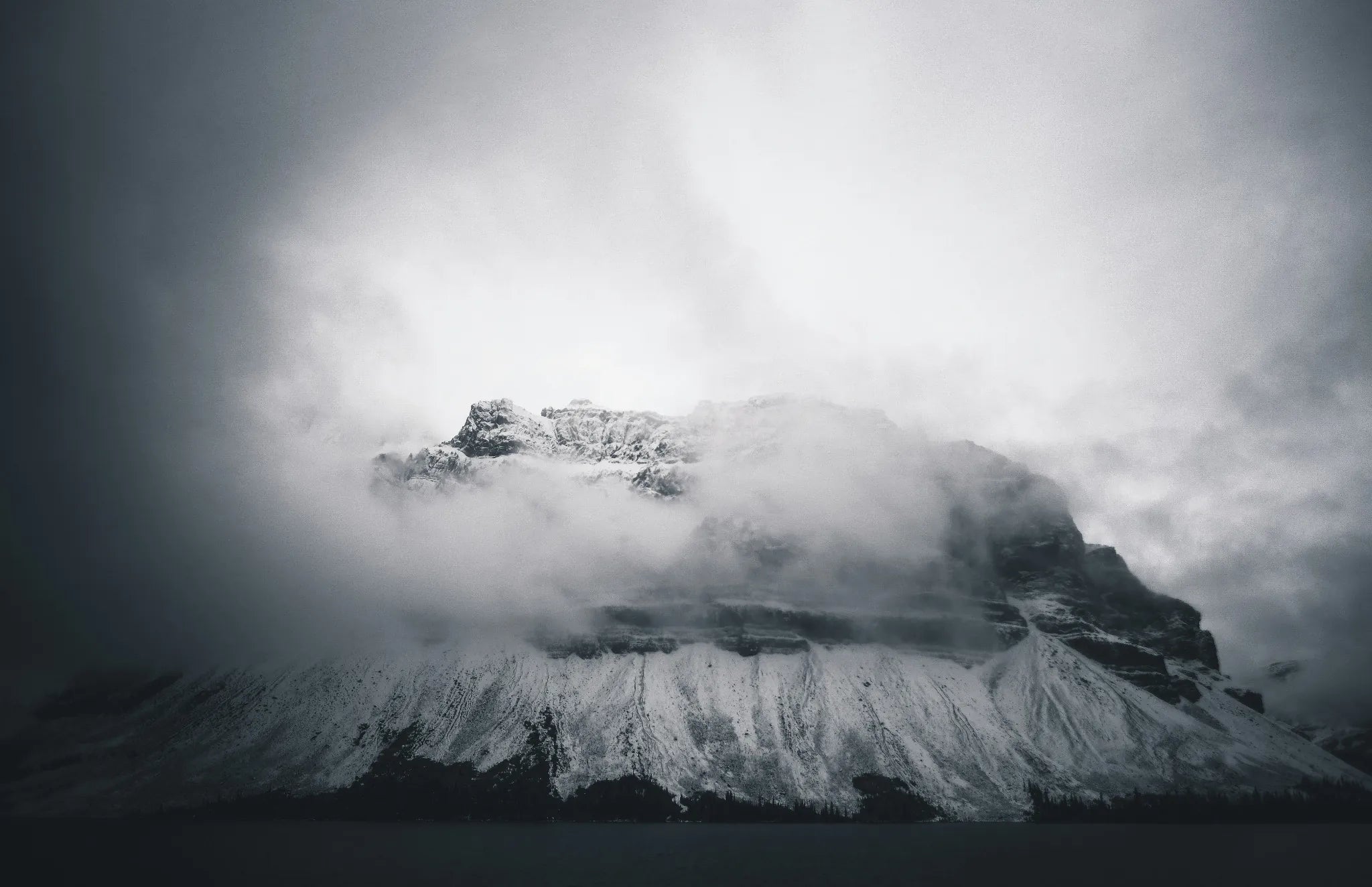 Sommet enneigé dissimulé par les nuages dans une ambiance de froid extrême.