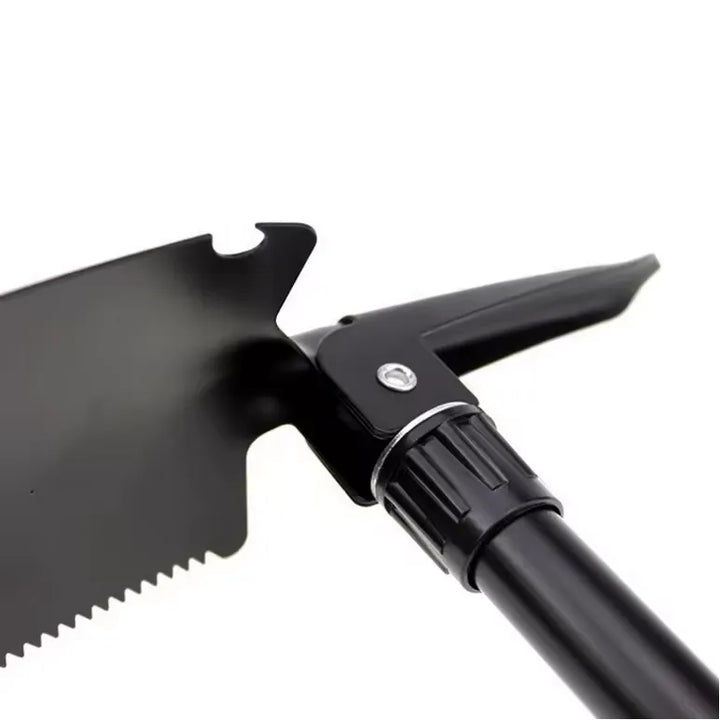 Pelle de survie robuste en acier avec bord denté, pliable et adaptée à la randonnée.
