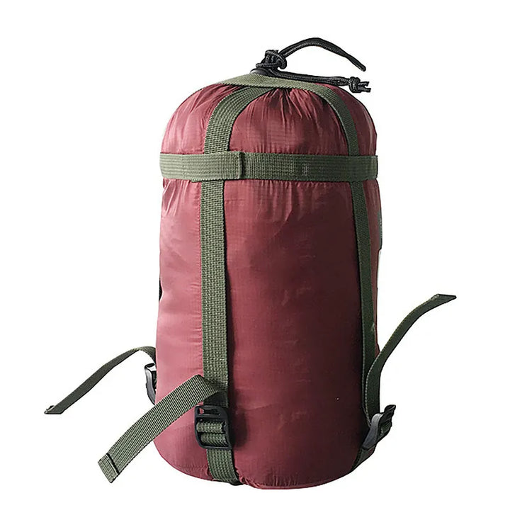 Sac de rangement pour sac de couchage bordeaux avec système de compression.