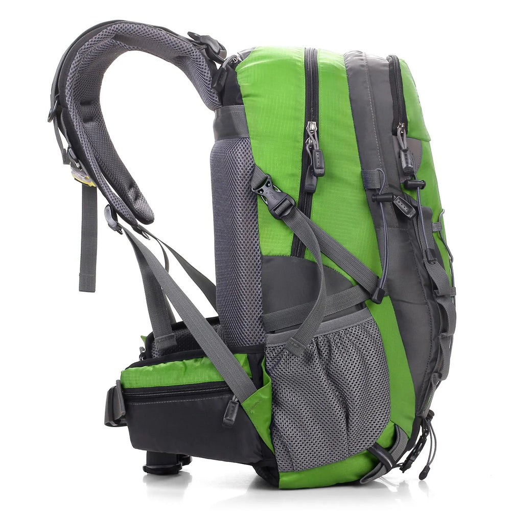 Vue latérale d’un sac à dos de randonnée vert et gris montrant les sangles de compression, la poche latérale et la ceinture de hanche.