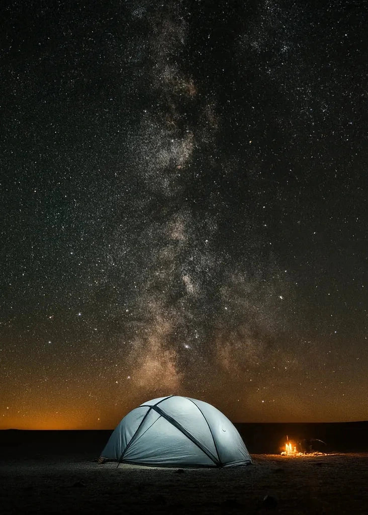 Tente de randonnée ultralight installée sous un ciel étoilé avec feu de camp.